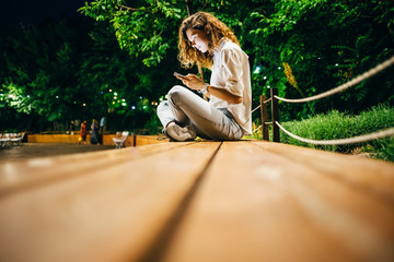 Happy young woman sitting relaxed on bench