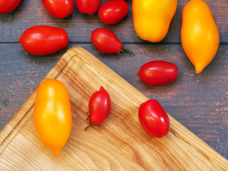 yellow and red tomatoes of different shapes and sizes on a rustic table.