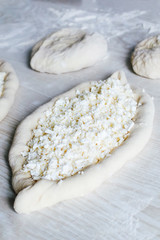 Homemade Ajarian Khachapuri with Suluguni Cheese. Stage of work. Preparation for baking. Raw Suluguni before baking