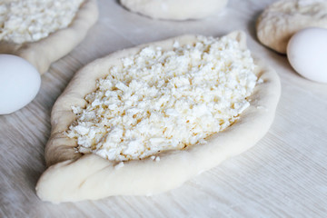 Homemade Ajarian Khachapuri with Suluguni Cheese. Stage of work. Preparation for baking. Raw Suluguni before baking