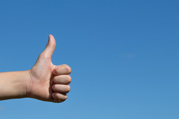 hand with thumb up on blue sky