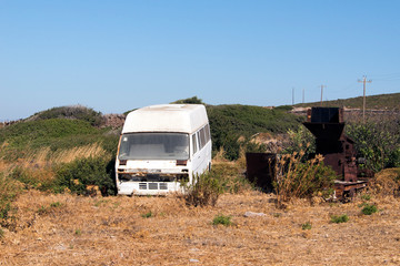 A wrecked minibus in a junk yard