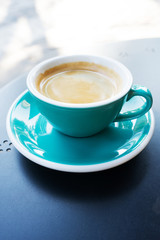 A cup of coffee on the table. A fresh morning coffee time in a street cafe.  
