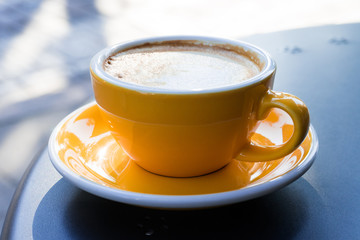 A cup of coffee on the table. A fresh morning in a street cafe.  