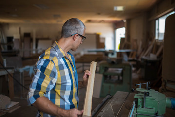 Obraz premium a carpenter measures a massive piece of wood