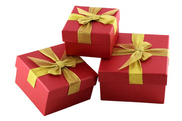 Small gifts wrapped in red paper with gold ribbon on white background. Gifts can be for Christmas, birthday or Valentine's Day.