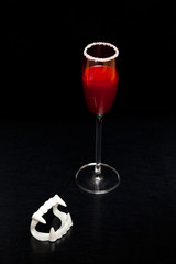 Bloody Halloween vampire drink on black background with space for copy text.