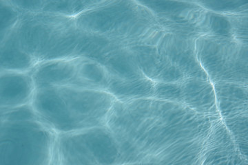 Close up full frame view of the reflecting water surface of a sunlit swimming pool