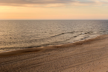 Beautiful sunset seascape with sand beach in evening.