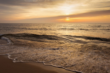 Beautiful sunset seascape with the sun and small waves.