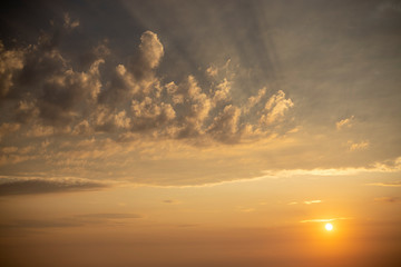 Obraz na płótnie Canvas Sun low in the sky under light clouds