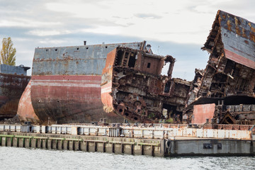 Huge rusty pieces of decommissioned marine ship that was cut and left on the shore.