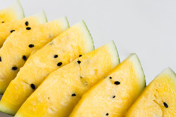 several slices of ripe yellow watermelon on white background