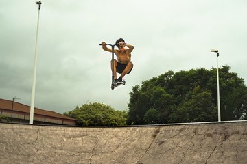 Skater boy training in city skate park outdoor . Young trendy man performing skills and tricks with...
