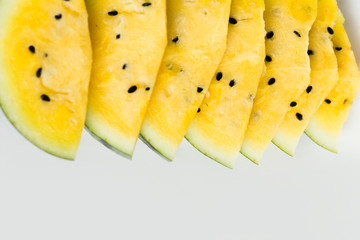 several slices of ripe yellow watermelon on white background