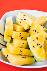 triangular slices of ice cream on a stick of ripe yellow watermelon in a plate