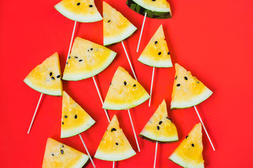 a lots of triangular pieces of ice cream on a stick of ripe yellow watermelon