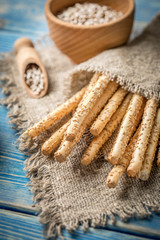 Fresh baked grissini bread on wooden board.