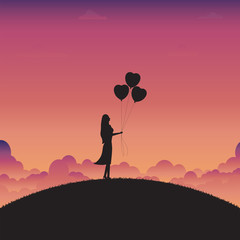 Woman standing holding a heart balloons on sunset background