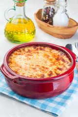 Greek dish moussaka made in traditional ceramic pot, vertical