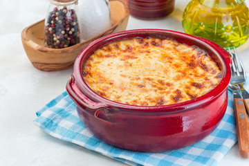 Greek dish moussaka made in a traditional ceramic pot, horizontal
