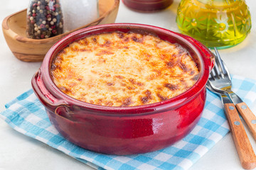 Greek dish moussaka made in traditional ceramic pot, horizontal