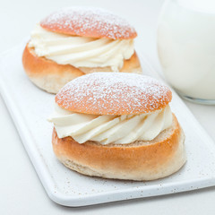 Traditional swedish dessert Semla, also called Shrove bun, with almond paste and whipped cream filling, served with milk,  square