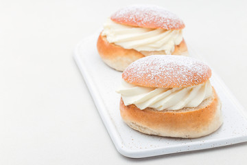 Traditional swedish dessert Semla, also called Shrove bun, with almond paste and whipped cream filling, horizontal, copy space