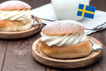 Traditional swedish dessert Semla, also called Shrove bun, with almond paste and whipped cream filling, served with milk,  horizontal