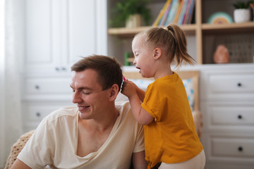 Caucasian father and daughter, girl playing dad