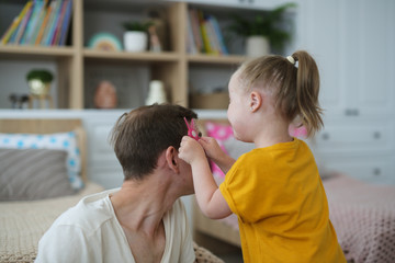 Caucasian father and daughter, girl playing dad