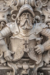 Very old statute of scary and heavy armed gatekeeper, medieval warrior with weapon in historical...