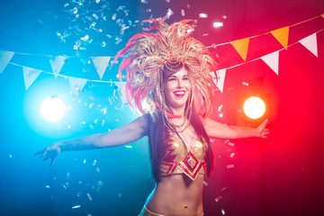 Carnival, dancer and holiday concept - Portrait of a sexy female in a colorful sumptuous carnival feather suit. Nightlife of female dancer