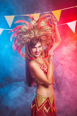 Fototapeta na wymiar Carnival, dancer and holiday concept - Portrait of a sexy female in a colorful sumptuous carnival feather suit. Nightlife of female dancer