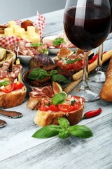 Italian antipasti wine snacks set. Cheese variety, Mediterranean olives, Prosciutto di Parma, tomatoes, artichokes