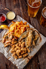 Set seafood: mussels, shrimps, small fried sea fish, crackers and sauces, food that is usually served with beer, vertical orientation