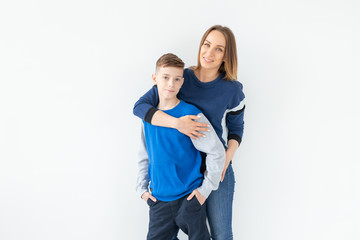 Parenting, family and single parent concept - A happy mother and teen son laughing and embracing on white background with copy space