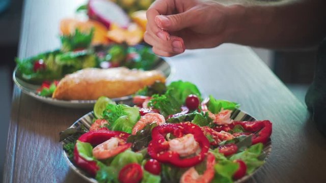 Close up of Hands Salt Salad Slow Motion. Fresh Green vegetables and Shrimps.