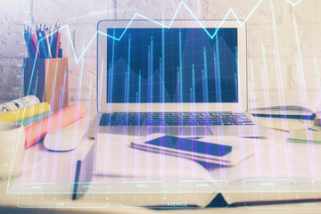 Stock market graph on background with desk and personal computer. Multi exposure. Concept of financial analysis.