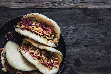 Steamed vegan bao buns with vegetables and peanuts.
