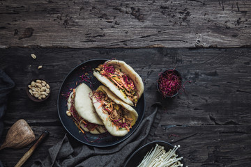 Steamed vegan bao buns with vegetables and peanuts.