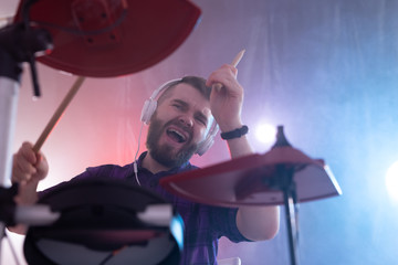 emotions, drums, hobby and people concept - rock musician playing the drums on the stage