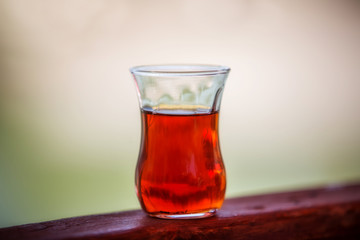 Glass with turkish black tea close-up in backlight