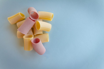 Uncooked pasta on neutral background. Meal based on flour. Italian healthy food. Copy space