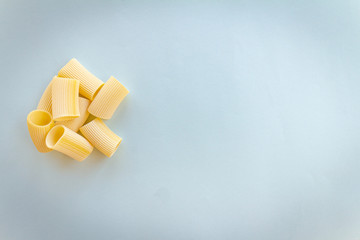 Uncooked pasta on neutral background. Meal based on flour. Italian healthy food. Copy space