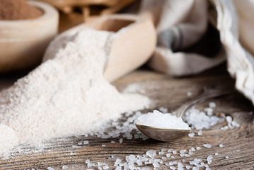 salt crystals on old metal spoon, weathered wooden table