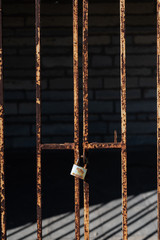 rusty lock on barred gate