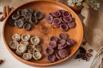 Assortment of sweets without sugar and gluten on a wooden dish. Dessert made from healthy natural ingredients. Beautiful composition of healthy diet candies and flowers