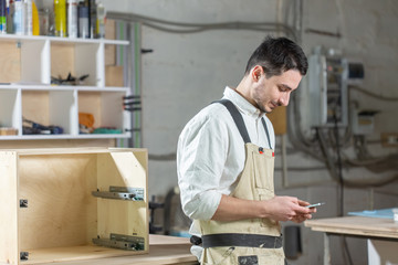 furniture factory, Small-Sized Companies and people concept - Young worker works in a factory for the production of furniture