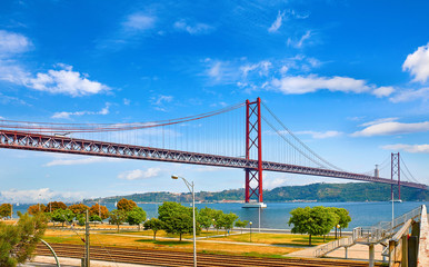 25th April Bridge in Lisbon, Portugal. Famous landmark on river Tagus. Summer sunny landscape with blue sky.